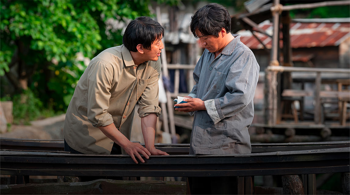 Two men on a bridge sharing a bible